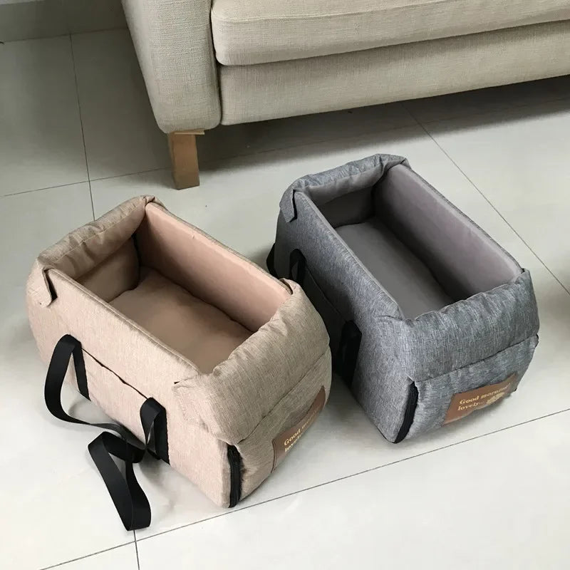 Two rectangular pet travel beds with handles, beige and gray, on tiled floor near sofa at Carcader