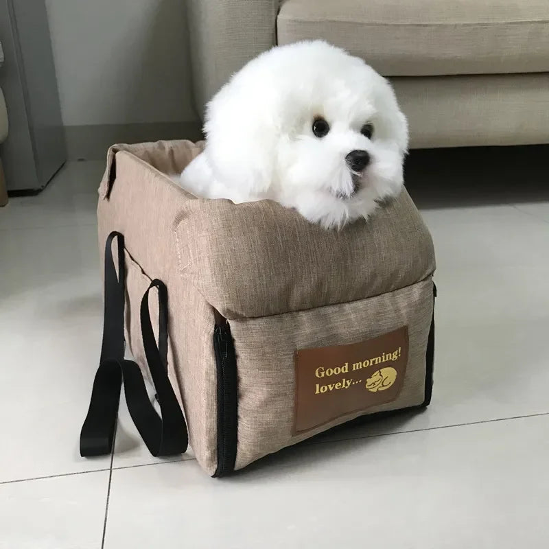 Fluffy white dog sitting in beige pet carrier bag with 'Good morning! lovely...' label indoors