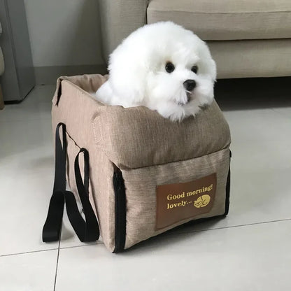 Fluffy white dog sitting in beige pet carrier bag with 'Good morning! lovely...' label indoors