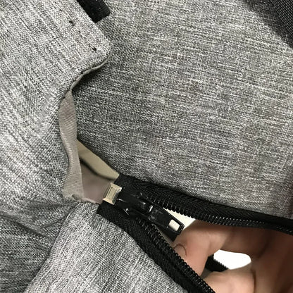 Close-up of gray fabric Carcader bag with black zipper partially open.