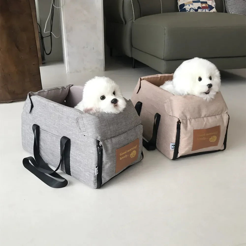 Two small white dogs in soft pet carrier bags on a modern living room floor, Carcader